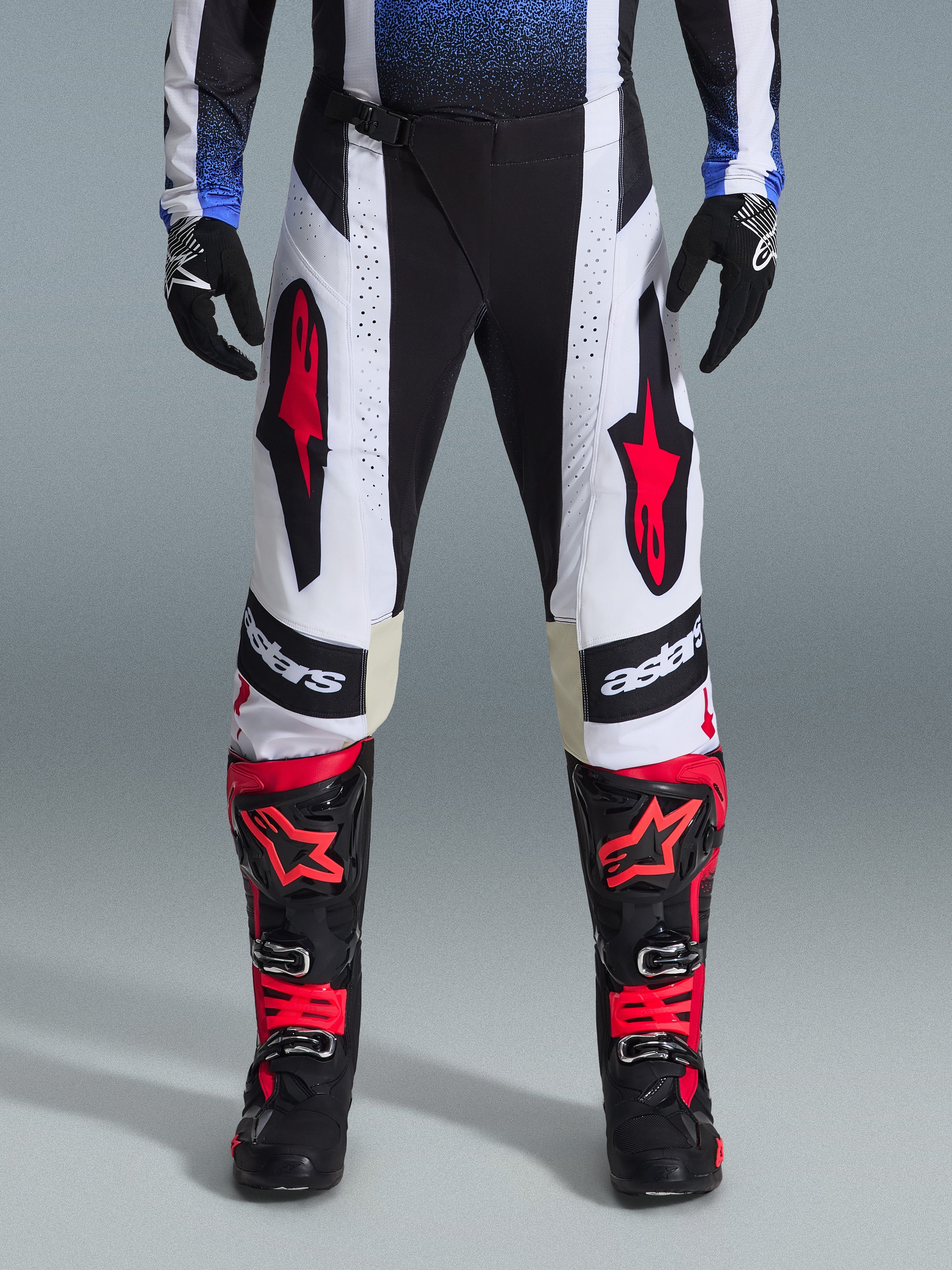 Alpinestars 2026 Techstar Knif bukser, motocross-bukser, sort, hvid og rød, båret med matchende røde og sorte støvler og sorte handsker, fremtrædende røde stjernelogoer på hvide paneler og tekniske perforerede detaljer til off-road racing