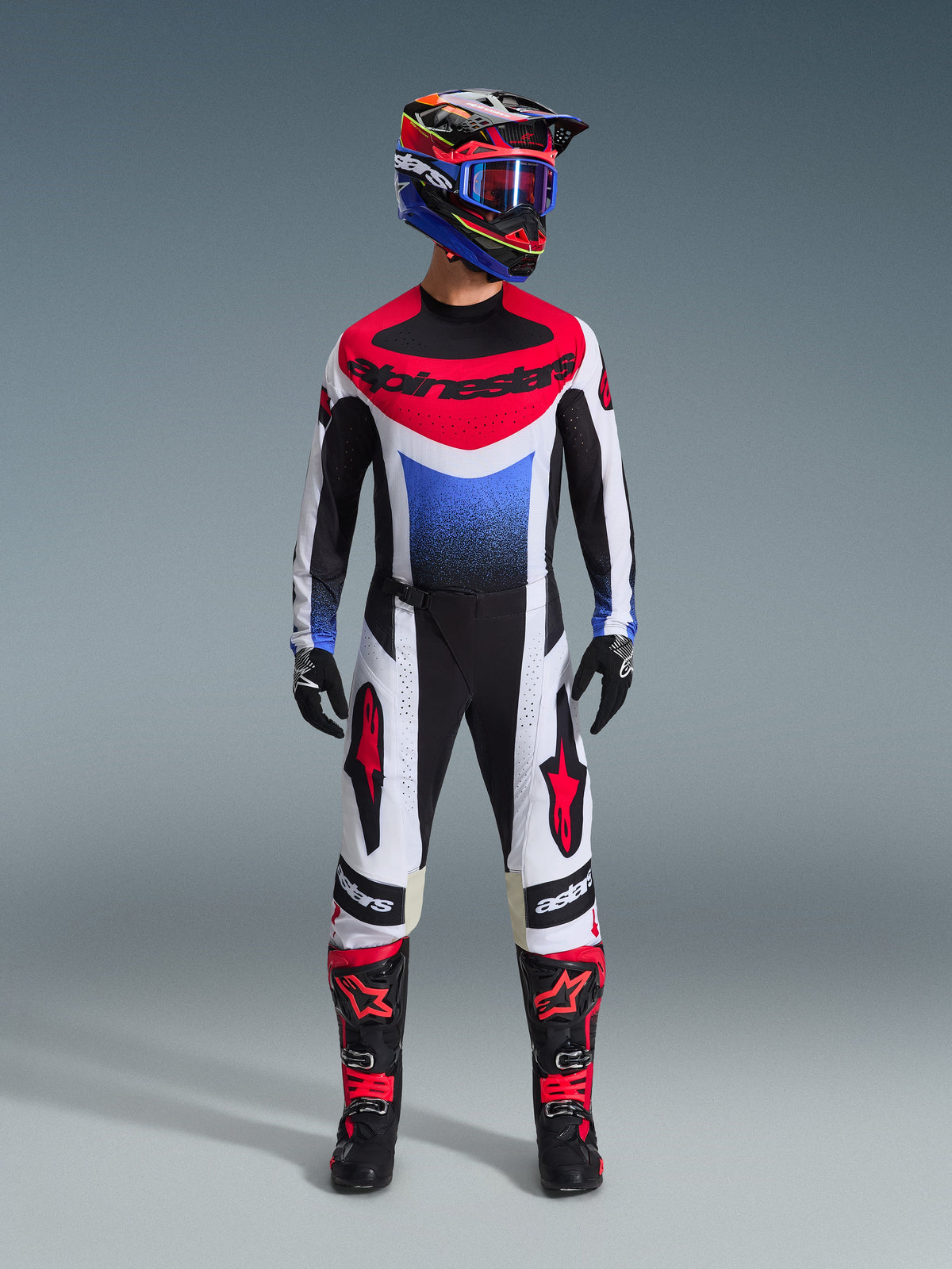 Alpinestars 2026 Techstar Knif Gear Set, motocross-outfit, rød, hvid og blå jersey med Alpinestars-logo, matchende hvide og sorte bukser med røde detaljer, farverig racerhjelm med blå goggles, sorte støvler med røde accenter, komplet MX-racersæt