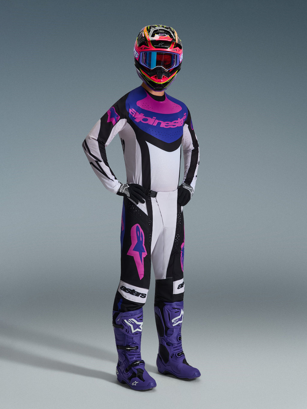 Alpinestars 2026 Techstar Knif Gear Set, motocross-udstyr, sort, lys grå og lilla, hvid trøje med blå og lyserøde detaljer, matchende bukser med lilla stjernelogoer, farverig lyserød og gul hjelm, lilla motocross-støvler og sorte handsker, professionelt udstyr til terrænkørsel