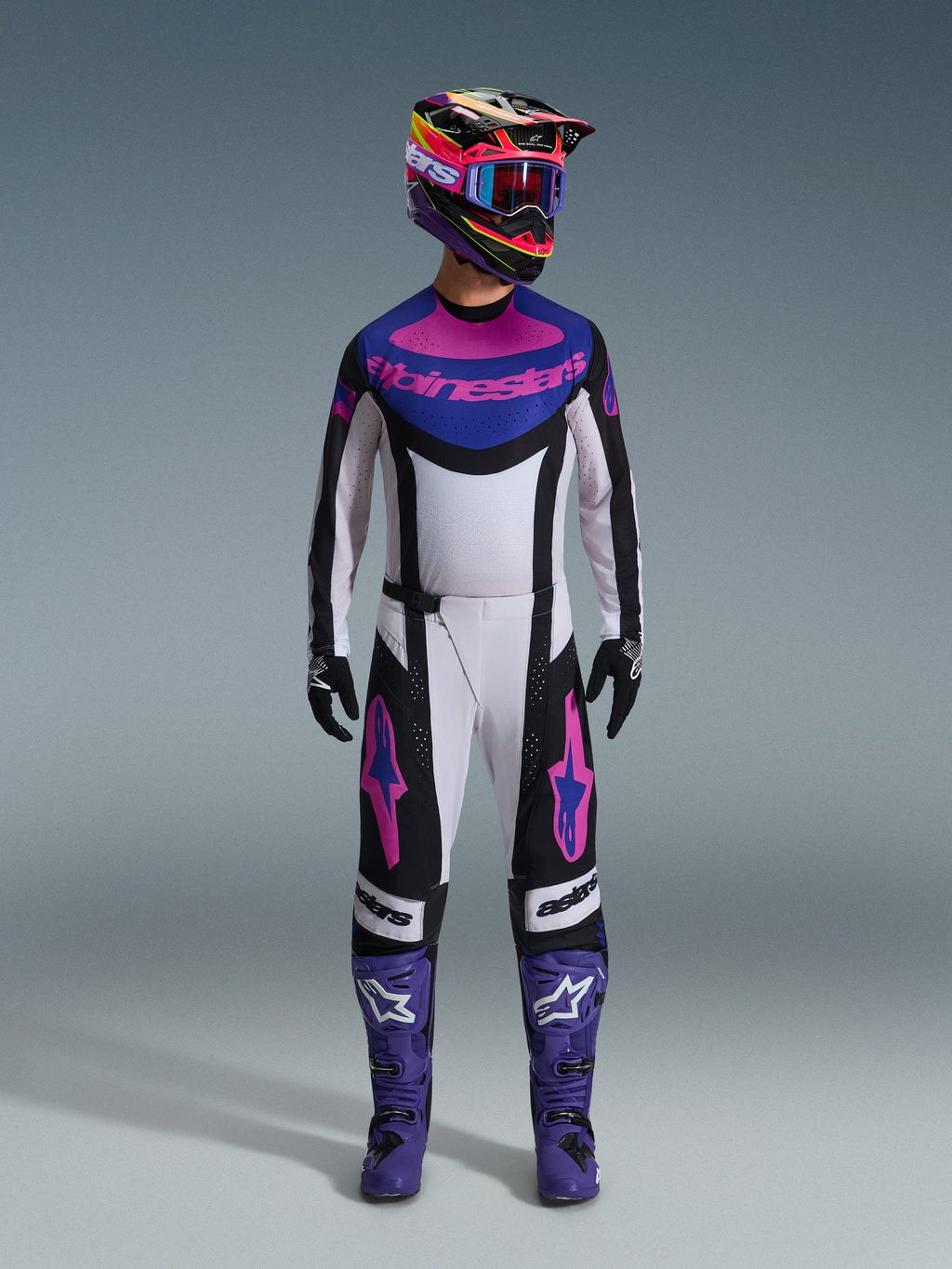 Alpinestars 2026 Techstar Knif-udstyrssæt, komplet motocross-udstyr, hvid, sort, lilla og pink, båret med en flerfarvet hjelm, blå goggles, lilla støvler og sorte handsker, koordineret high-performance udstyr til terrænkørsel