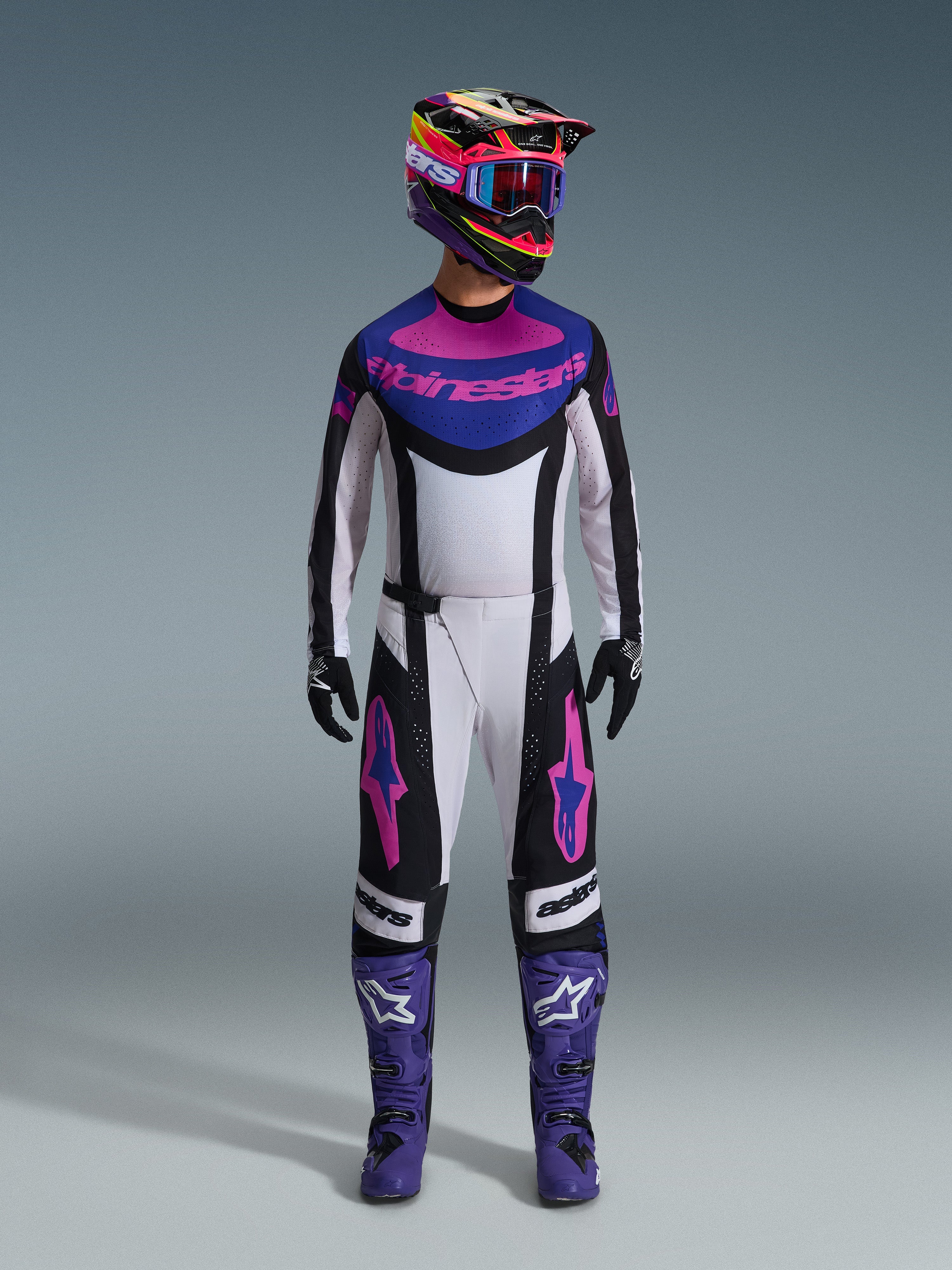 Alpinestars 2026 Techstar Knif-udstyrssæt, komplet motocross-udstyr, hvid, sort, lilla og pink, båret med en flerfarvet hjelm, blå goggles, lilla støvler og sorte handsker, koordineret high-performance udstyr til terrænkørsel