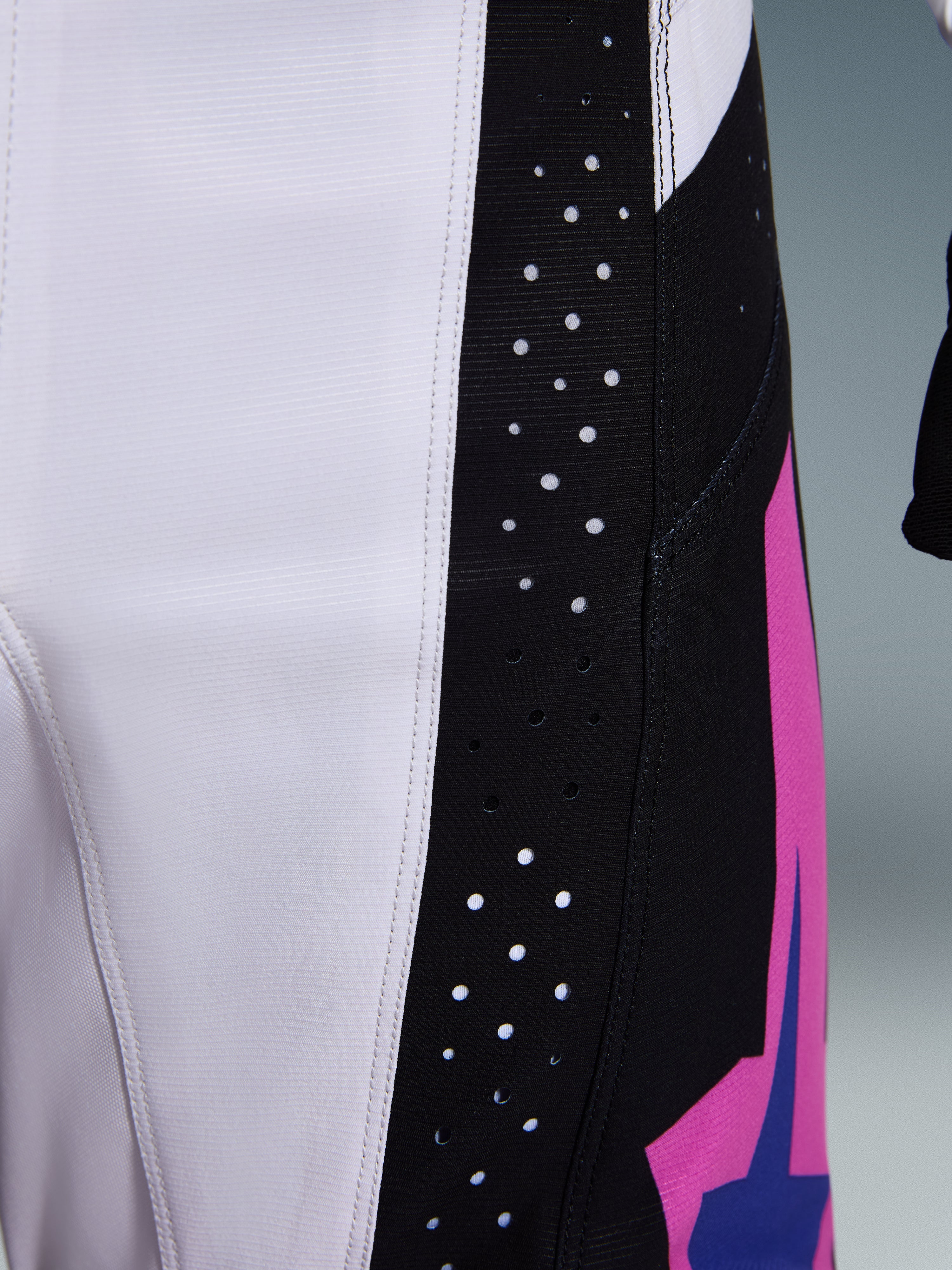 Alpinestars 2026 Techstar Knif bukser, motocrossbukser, sort, lysegrå og lilla, nærbillede af detalje med laserskårne perforationer på det sorte sidepanel for ventilation, holdbar ripstop-stofkonstruktion