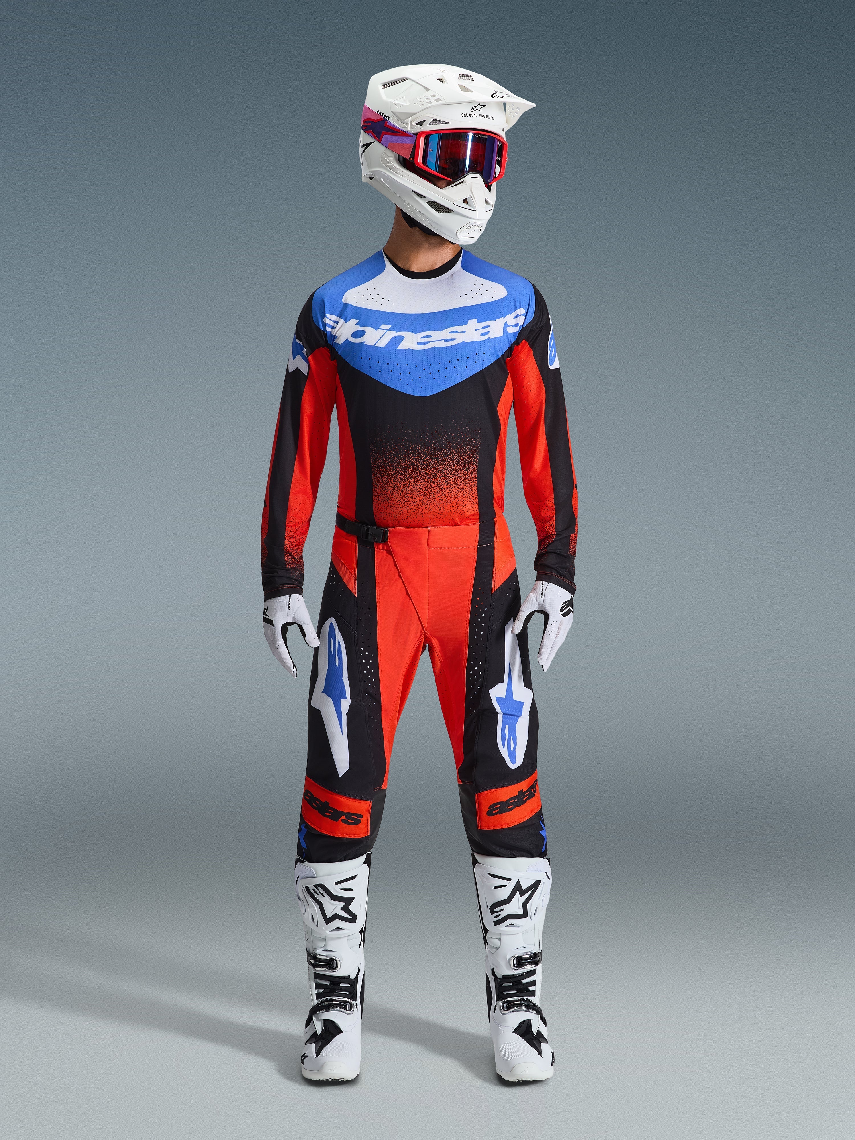 Alpinestars 2026 Techstar Knif Gear Set, motocross-udstyr, rød og sort med blå detaljer, komplet MX-outfit inklusiv trøje, bukser, hvid hjelm med lyserøde og blå detaljer, hvide handsker og hvide støvler, professionelt off-road racerudstyr