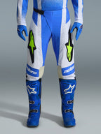 Alpinestars 2026 Techstar Knif bukser, motocross-bukser, Ucla-blå, sort og gul fluo, båret med matchende blå handsker og støvler, med hvide paneler og markante gul fluo-logoer, ergonomisk racingsnit til off-road ydeevne
