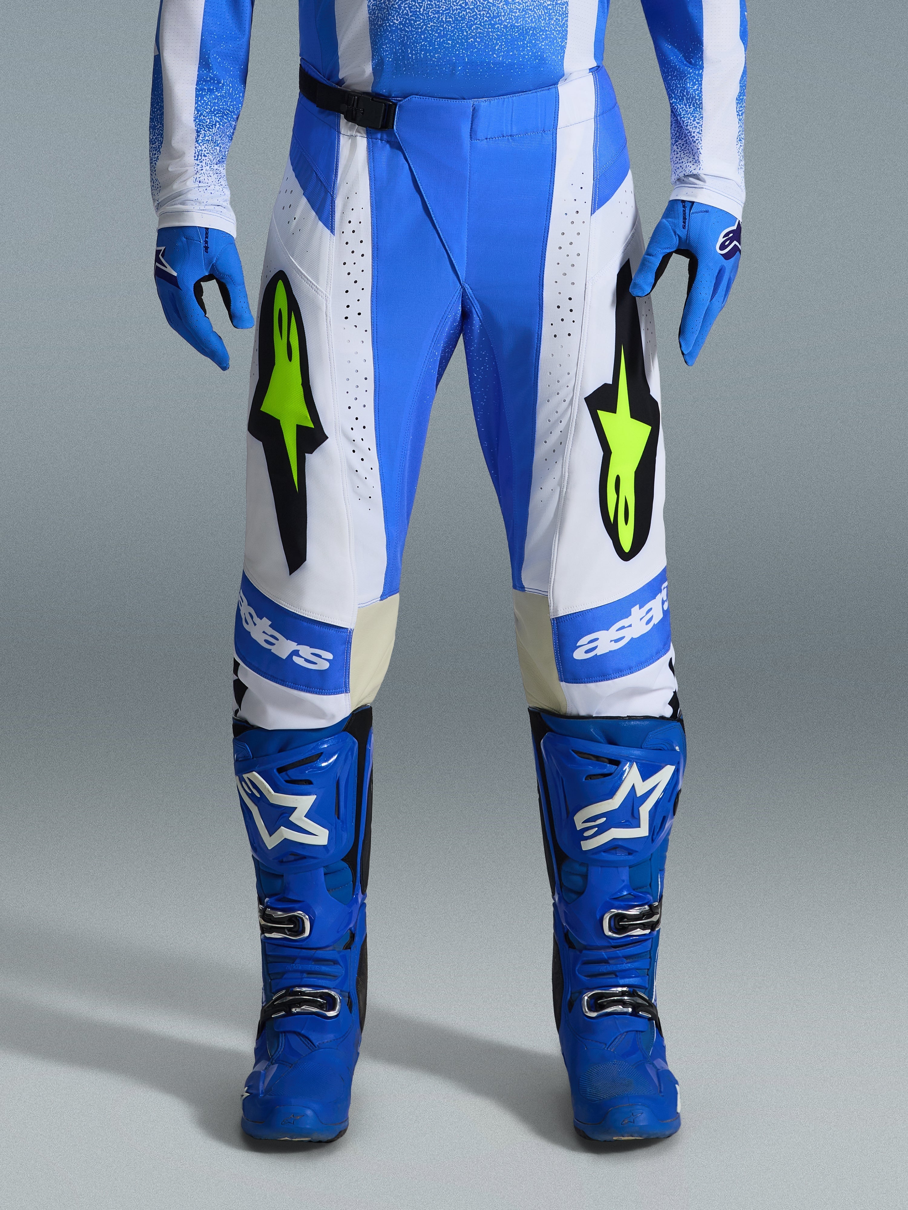 Alpinestars 2026 Techstar Knif bukser, motocross-bukser, Ucla-blå, sort og gul fluo, båret med matchende blå handsker og støvler, med hvide paneler og markante gul fluo-logoer, ergonomisk racingsnit til off-road ydeevne