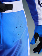 Alpinestars 2026 Techstar Knif bukser, motocross-bukser, Ucla Blue og sort, nærbillede af lår med laserskårne perforationer og SX2 magnetisk taljespænde, teknisk konstruktion til off-road racing