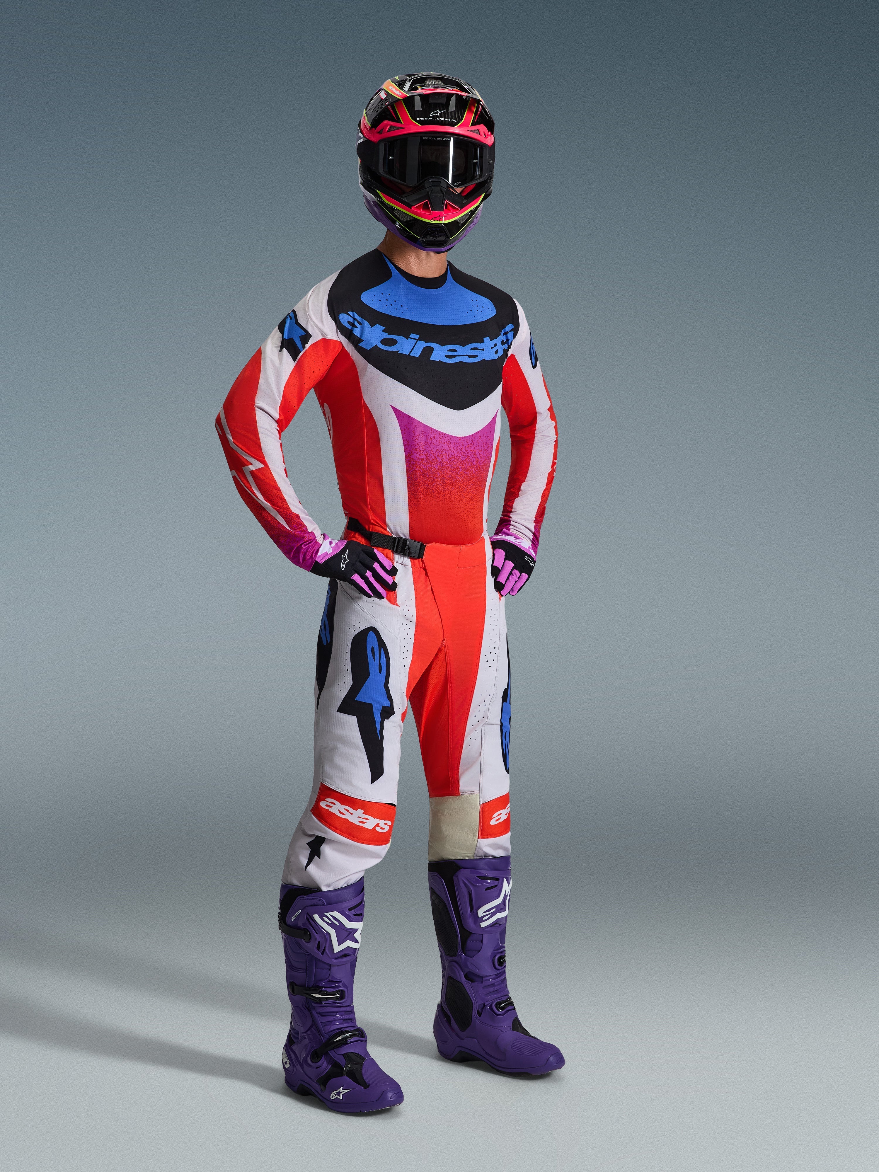 Alpinestars 2026 Techstar Knif gear-sæt, komplet motocross-udstyr, hvid og rød trøje med blå og lyserøde detaljer, matchende motocross-bukser, lilla støvler og en flerfarvet hjelm, koordineret professionelt outfit til terrænkørsel
