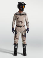 Alpinestars Racer Lone herre-udstyrssæt, tan ørkencamo motocrosstrøje og bukser på model, sort hjelm og motorcykelstøvler.