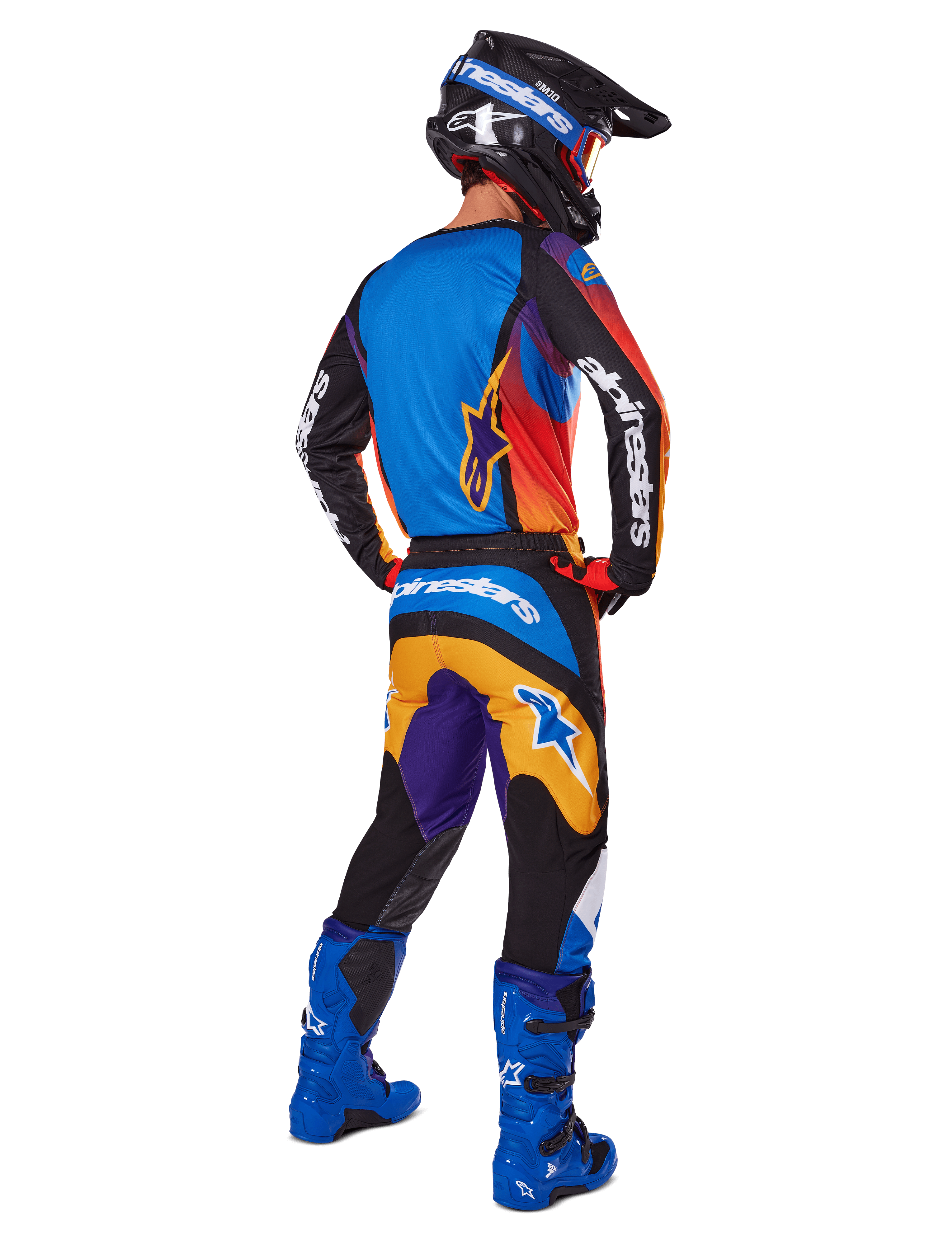 Motocross rider from the back wearing Alpinestars 2025 Fluid Wurx Pants, Multicolor design with blue, orange, yellow, and purple accents, paired with a matching jersey, bright blue boots, and black helmet, complete off-road racing gear.