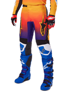 Alpinestars 2025 Fluid Wurx Pants, Motocross Pants, Multicolor orange red and purple gradient with black and blue panels, worn with blue boots and red gloves, featuring star logo graphics and white knee accents, durable performance gear for off-road racing