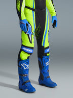 Alpinestars 2026 Techstar Nomur bukser, motocrossbukser, gul fluo, mørkeblå og UCLA Blue, båret med matchende blå støvler og handsker, med markante hvide logoer og forstærkede paneler, professionelt off-road racertøj