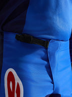Alpinestars 2026 Fluid Grid bukser, motocross-bukser, blå og rød, nærbillede af det sorte skraldelukningssystem i taljen, slidstærkt blåt polystof med rød og hvid logo-accent, konstrueret til off-road ydeevne