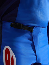 Alpinestars 2026 Fluid Grid bukser, motocross-bukser, blå og rød, nærbillede af det sorte skraldelukningssystem i taljen, slidstærkt blåt polystof med rød og hvid logo-accent, konstrueret til off-road ydeevne