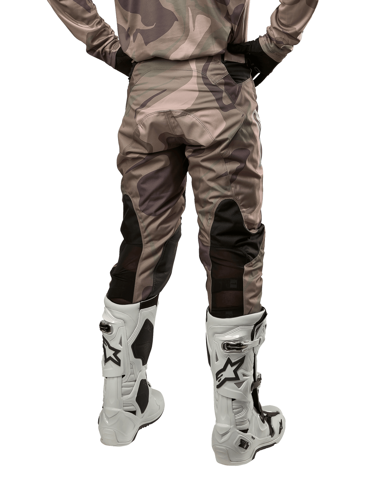 Alpinestars 2024 Racer Tactical bukser, motocrossbukser, Military Green Camo Brown, set bagfra med camouflagemønster og sorte åndbare strækpaneler på underbenene, båret med hvide motocrossstøvler, slidstærkt teknisk udstyr til off-road kørsel