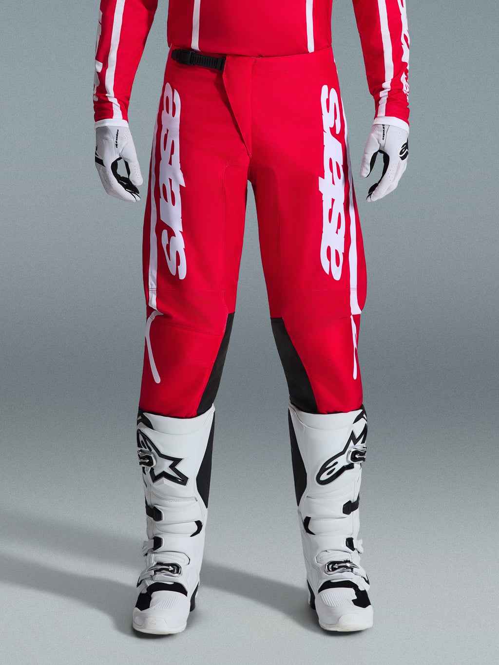 Alpinestars 2026 Fluid Apex bukser, motocross-bukser, rød og hvid, med store hvide Astars-logoer på lårene og sorte indvendige knæpaneler, båret med matchende hvide og sorte støvler og handsker for et komplet off-road racing-look.