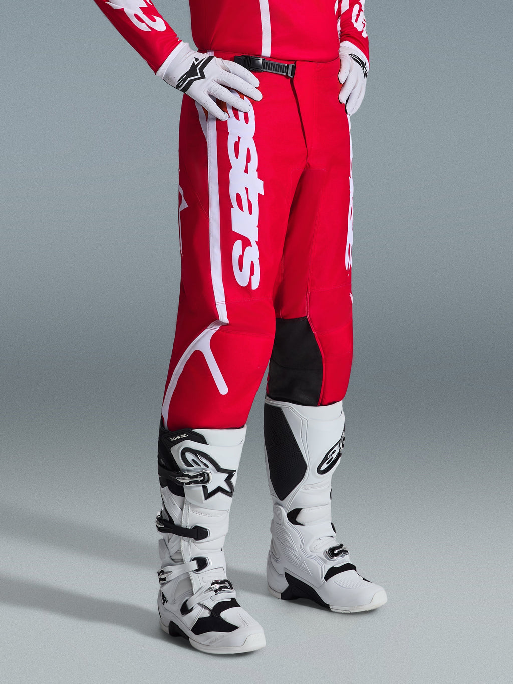 Alpinestars 2026 Fluid Apex bukser, motocross-bukser, rød og hvid, båret med hvide og sorte motocross-støvler og handsker, med markant hvid branding og sorte indvendige knæpaneler, designet til off-road ydeevne