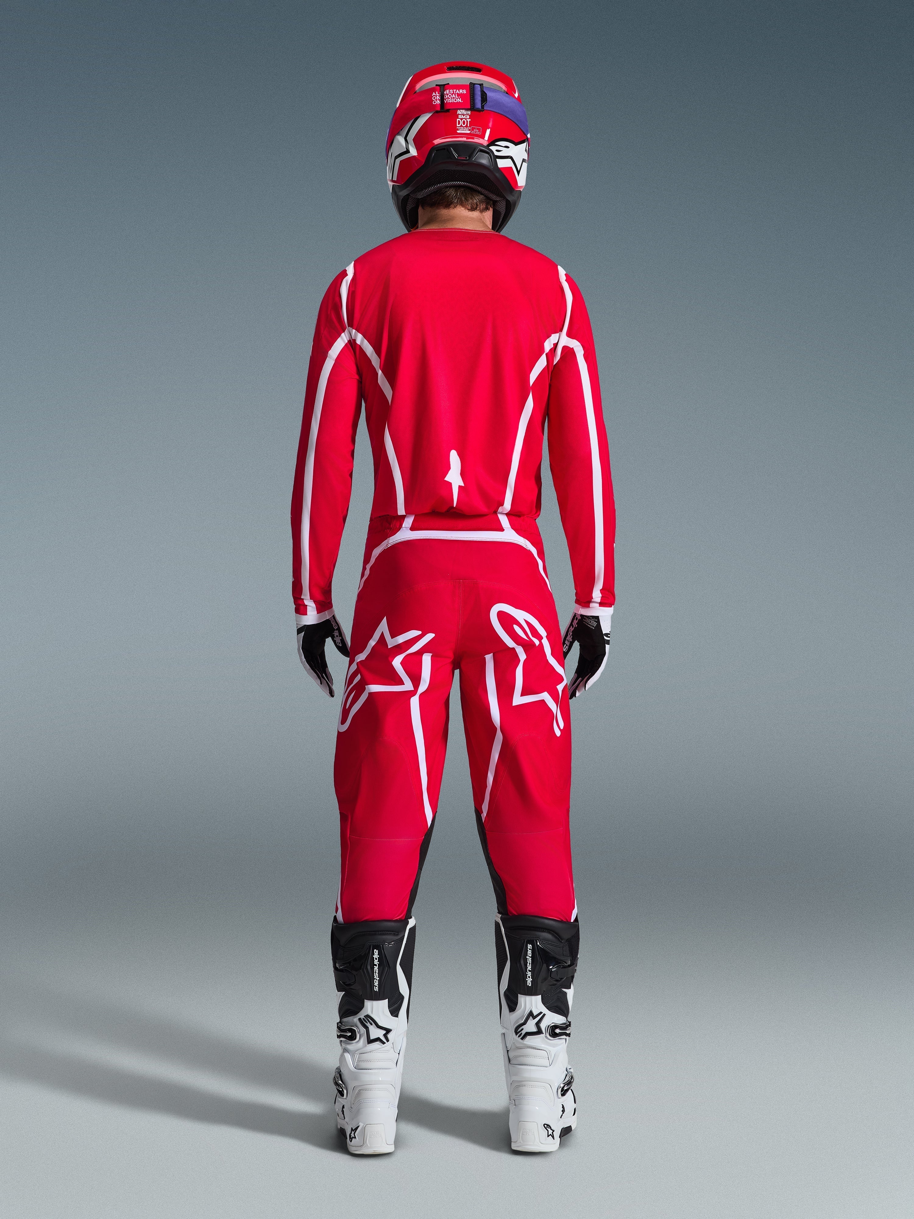 Alpinestars 2026 Fluid Apex bukser, motocross-bukser, rød og hvid, set bagfra båret med matchende trøje, rød hjelm og hvide og sorte støvler, med store hvide Astar-logoer på benene, koordineret sæt til off-road kørsel