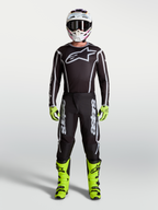 Alpinestars Fluid Apex V2 bukser i sort og sølv, herre-motocrossudstyr med neongule støvler, hjelm og racer-trøje.