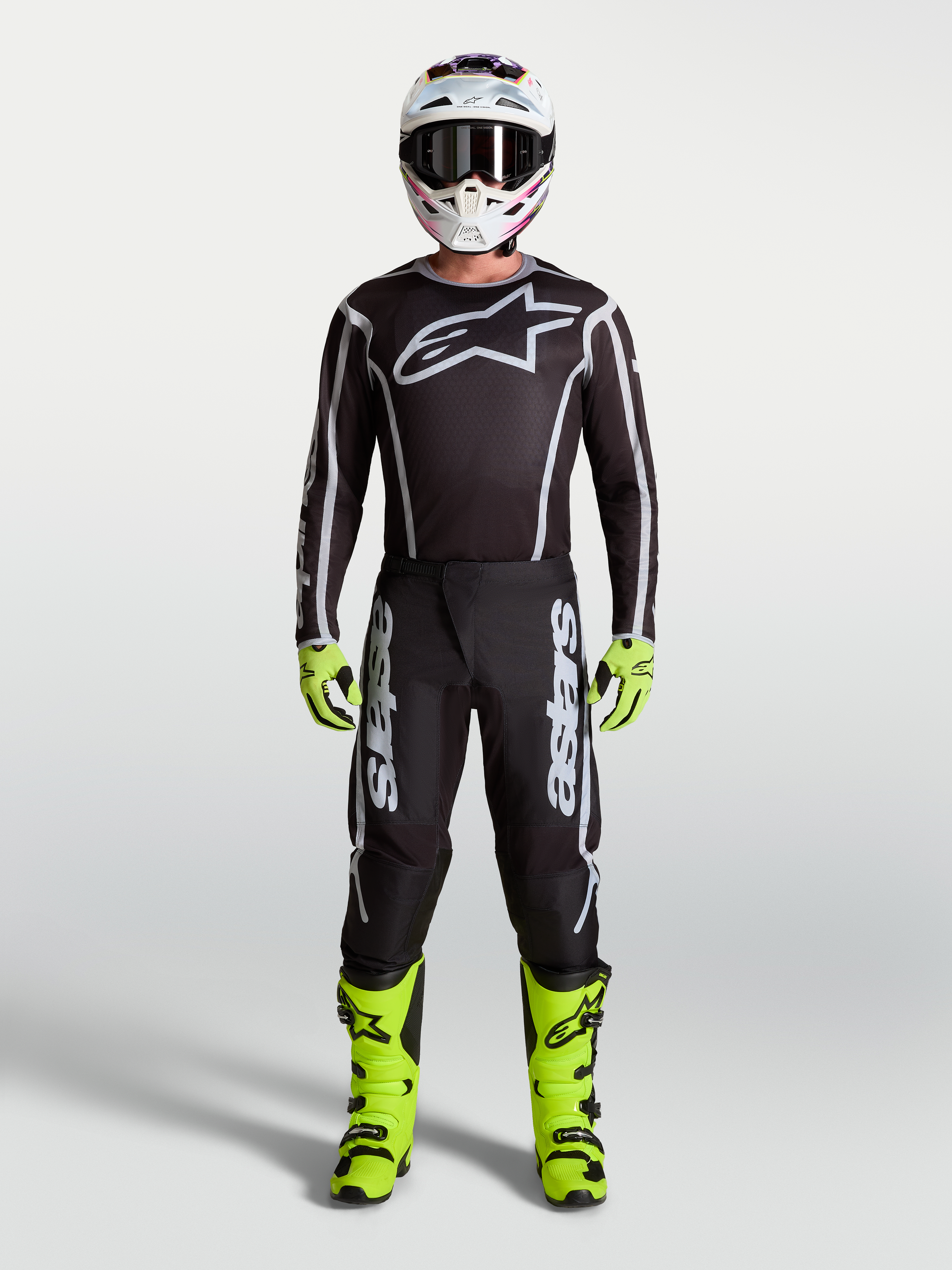 Alpinestars Fluid Apex V2 bukser i sort og sølv, herre-motocrossudstyr med neongule støvler, hjelm og racer-trøje.