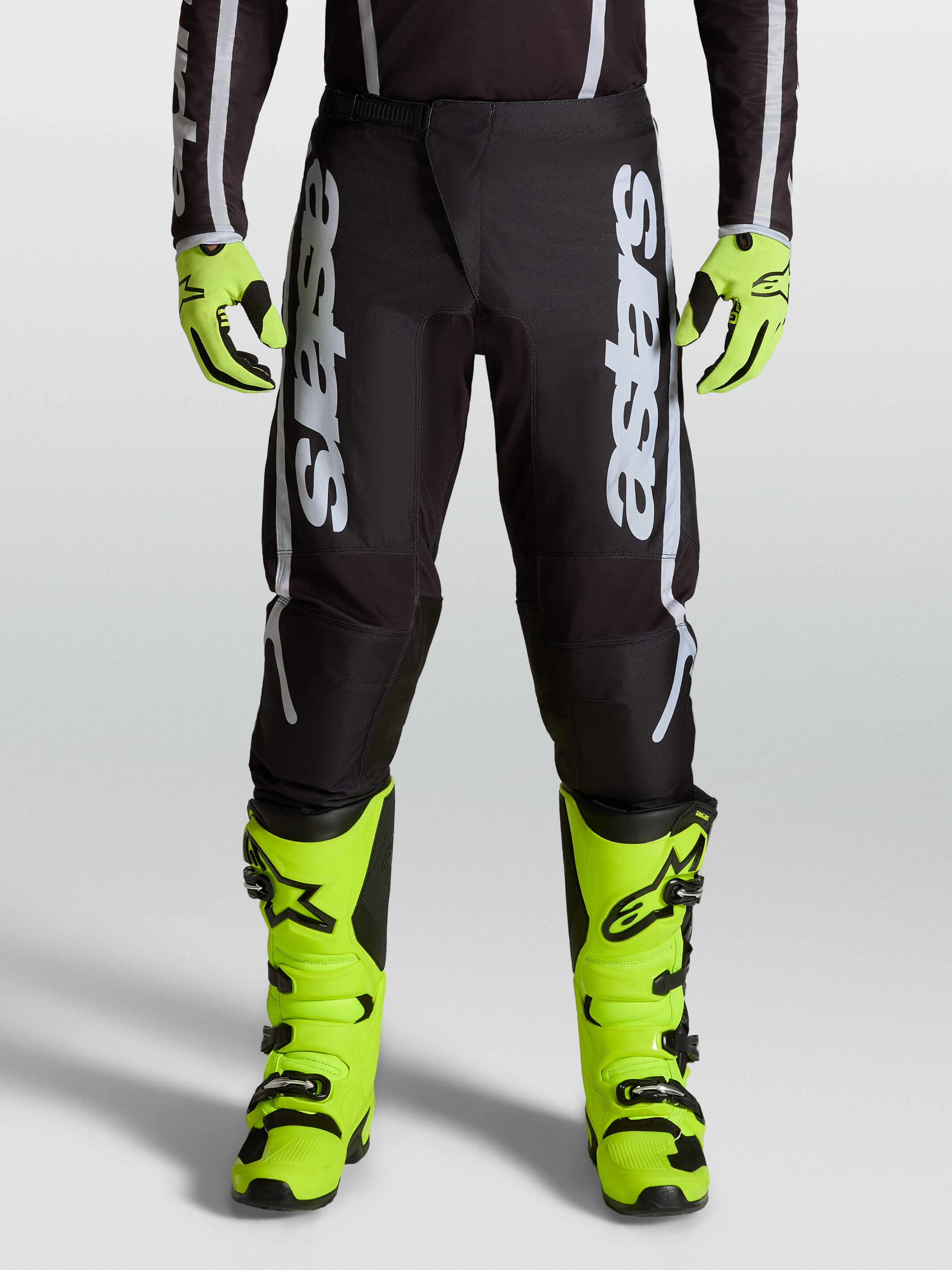 Alpinestars 2027 Fluid Apex V2 herre-motocrossbukser i sort og sølv med ergonomiske strækpaneler vist på model