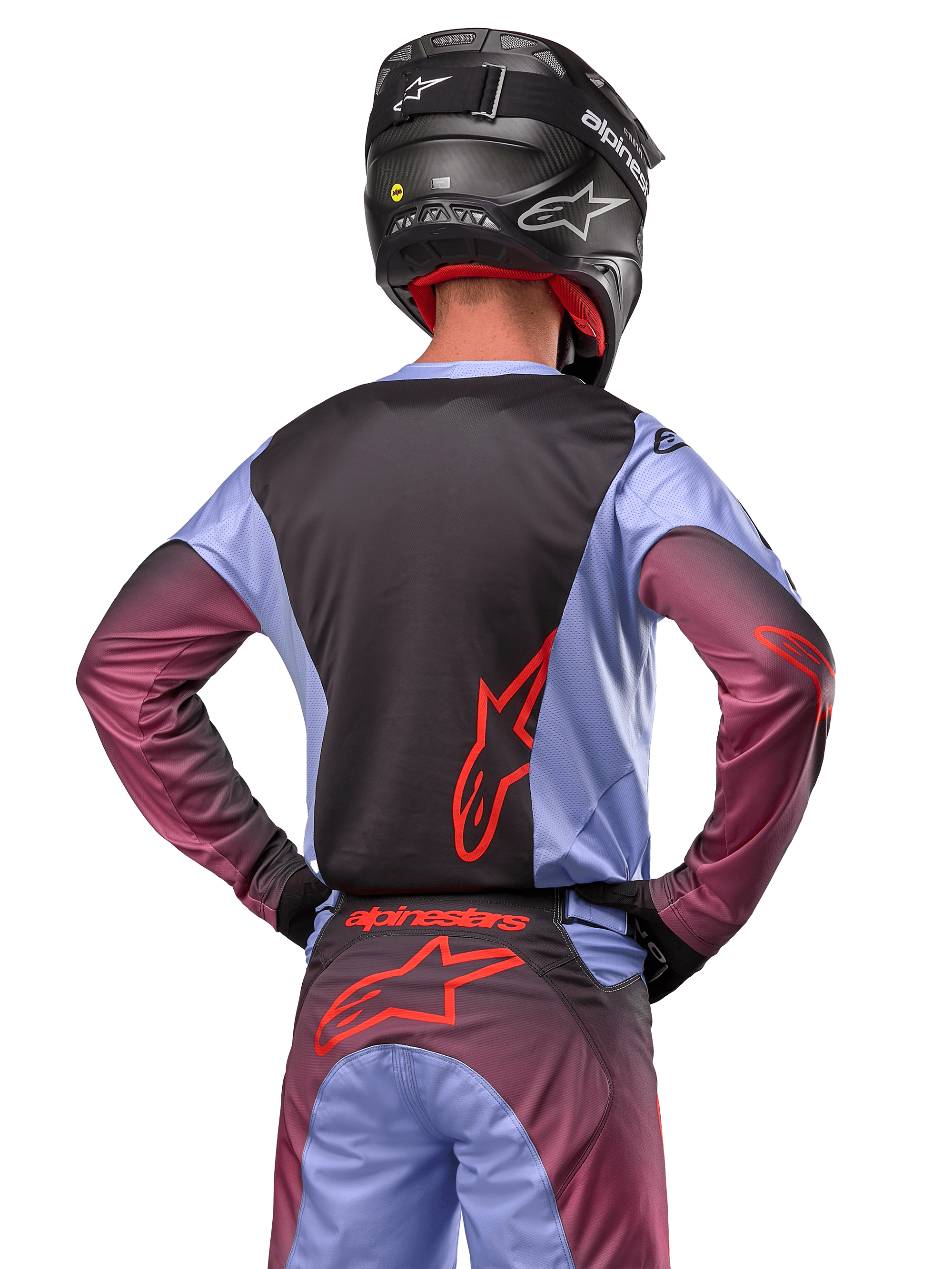 Alpinestars 2024 Racer Hoen-udstyr, motocrosskører set bagfra, Lavan Purple og sort jersey med rødt logo, matchende bukser med røde detaljer, sort hjelm, koordineret sæt til off-road racing