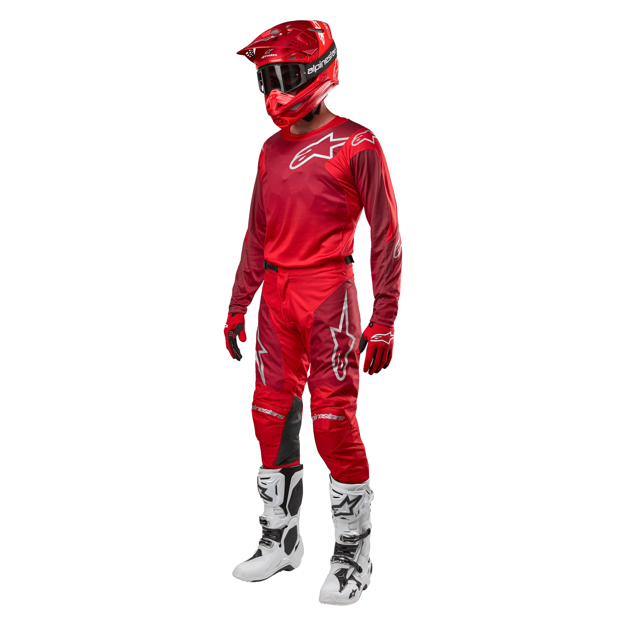 Motocross-kører iført komplet racerudstyr, Alpinestars 2024 Racer Hoen bukser og trøje i Mars Red Burgundy, rød hjelm, røde handsker og hvide og sorte støvler, koordineret outfit til terrænkørsel