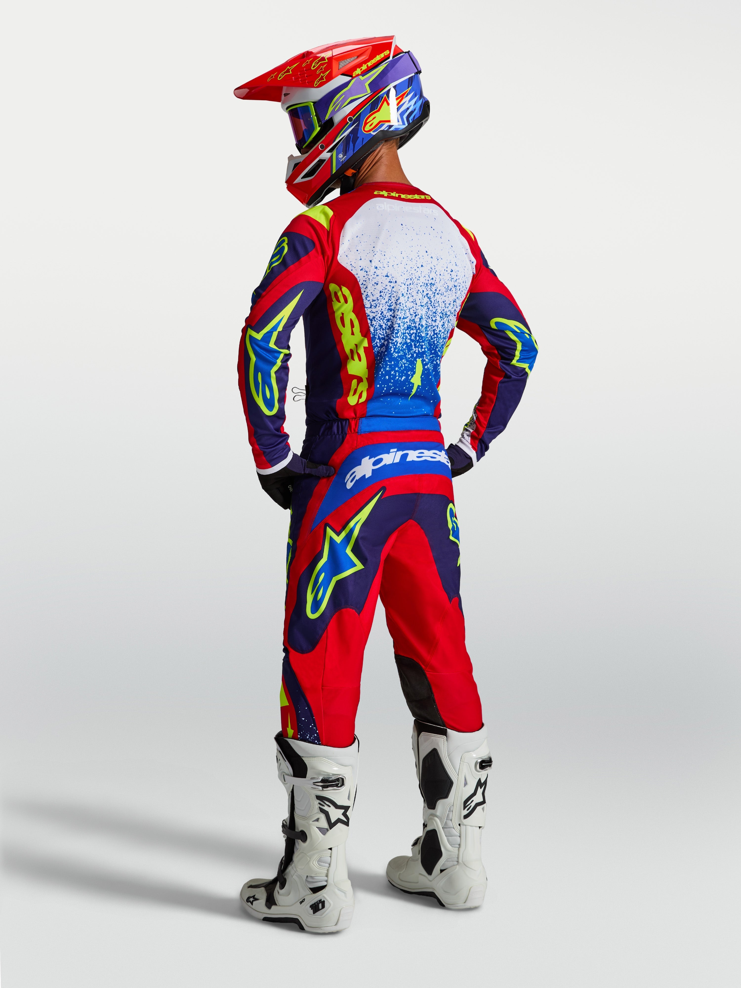 Alpinestars Fluid Drag bukser og 2027 Fluid Drag udstyrssæt, blå og rød herre-motocrossdragt med hvide støvler, set bagfra.