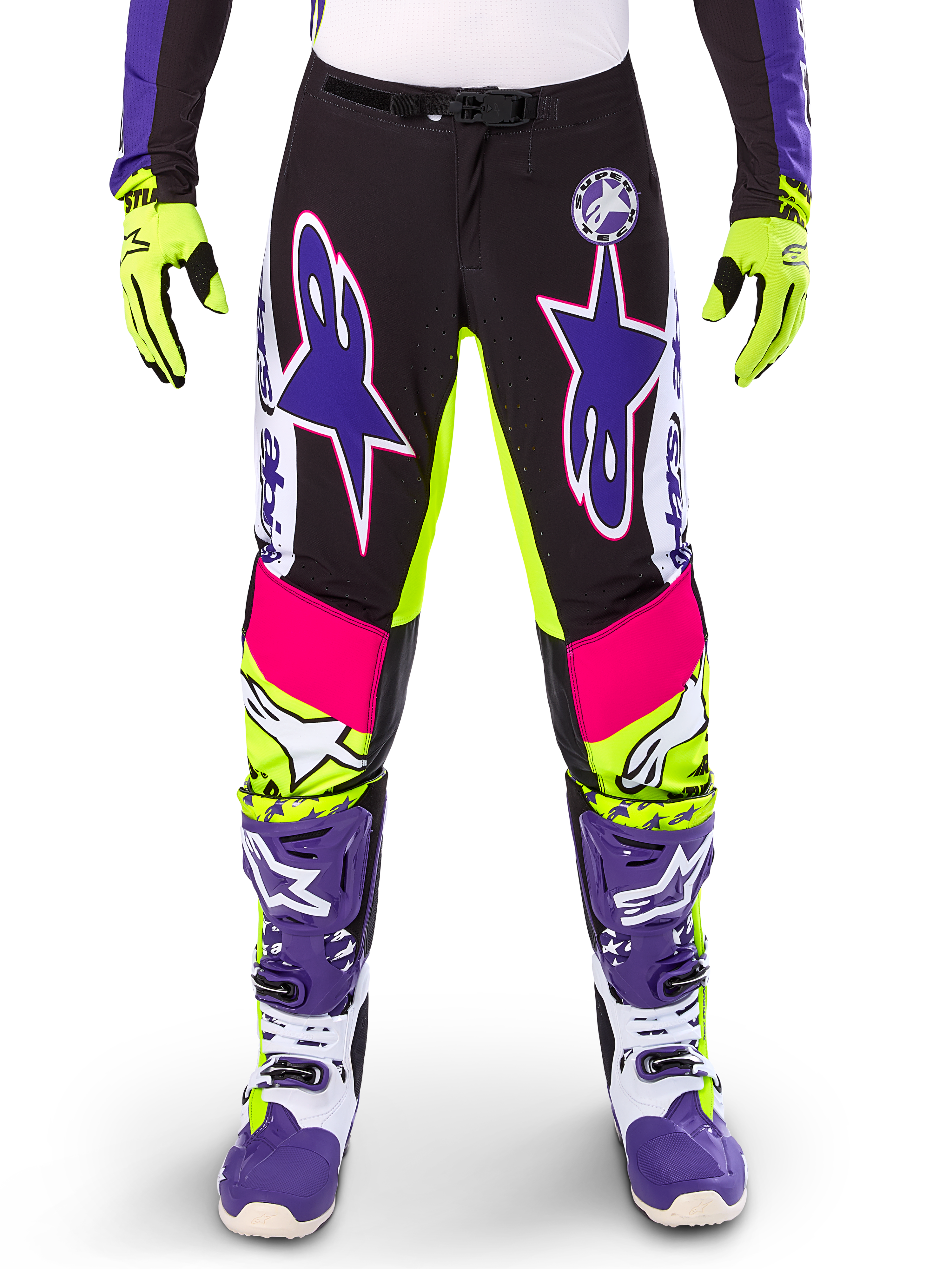 Alpinestars Limited Edition Supertech Dirt Studios bukser, motocrossbukser, hvid, lilla og neon gul, med sorte paneler og neon gule og lyserøde detaljer, store lilla stjernelogoer, vist med matchende neon gule handsker og lilla racingstøvler, holdbart off-road racertøj