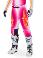Alpinestars Supertech AFD MIG Limited Edition motocross-bukser, pink med orange og gule stjernelogoer, vist med hvide motocross-støvler og sort-hvide handsker, sorte indvendige knæpaneler, atletisk pasform, en del af et high-performance racersæt