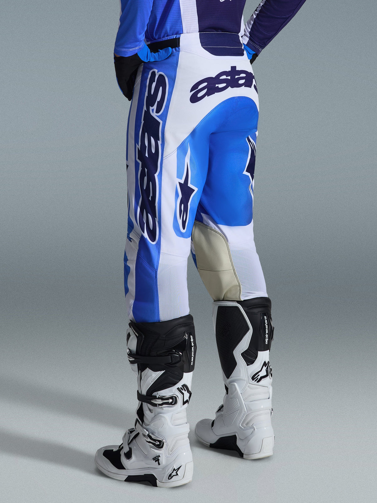 Alpinestars 2026 Racer Air Portl bukser, motocross-bukser, Ucla Blue White, set bagfra, markant blåt og hvidt design med stort logo på bagdel og side, forstærket gedelæder på indersiden af knæene, båret med hvide og sorte motocross-støvler til off-road kørsel.