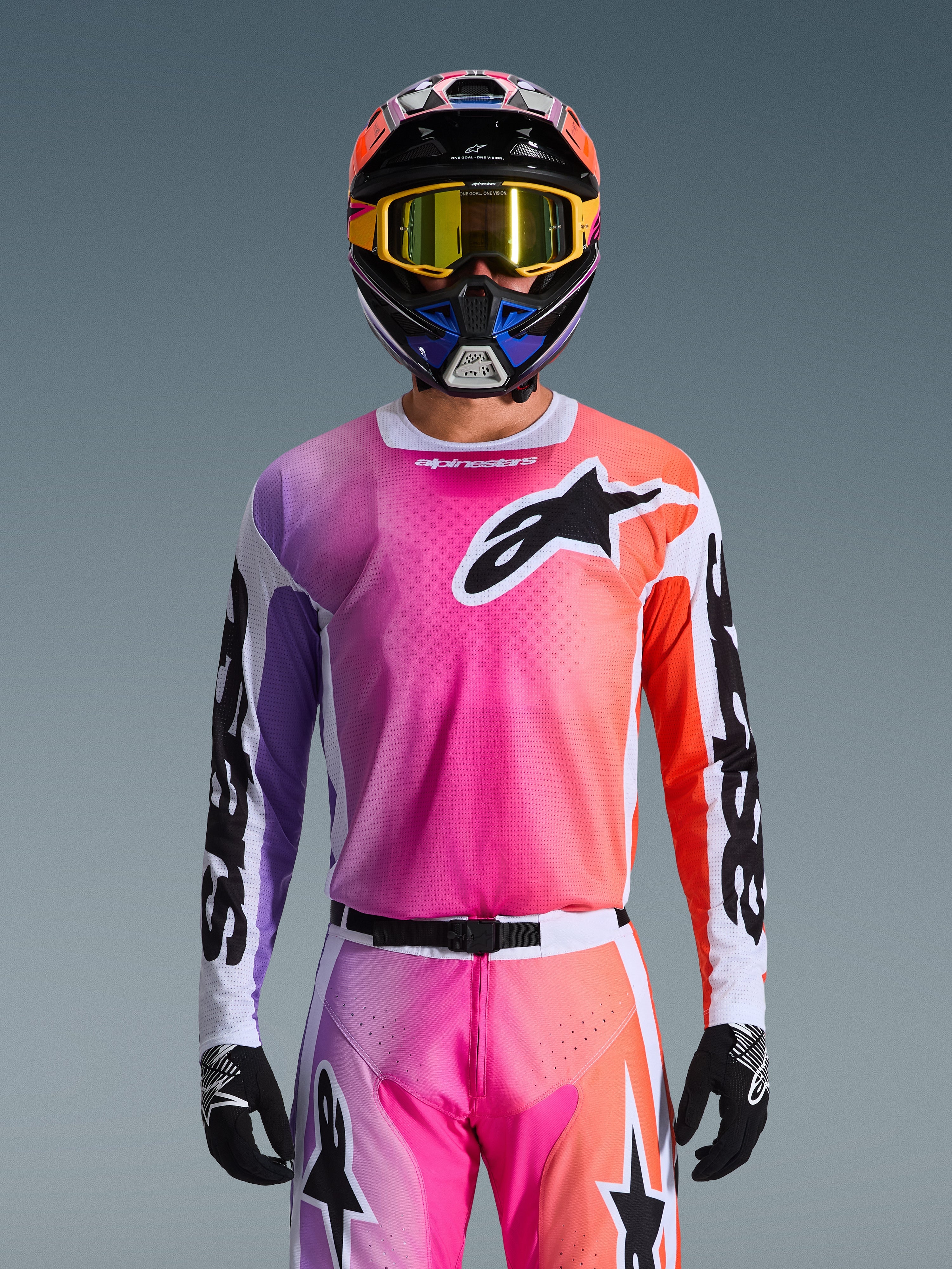 Alpinestars 2026 Racer Air Portl Jersey, Motocross Jersey, vibrant pink, purple, and orange gradient, worn with a matching helmet and goggles, featuring a large black star logo on the chest, breathable mesh construction, performance gear for off-road racing