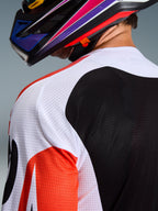 Alpinestars 2026 Racer Air Portl trøje, motocross-trøje, flerfarvet med hvide, sorte og røde paneler, nærbillede af den perforerede mesh-konstruktion på skulder og ryg for ventilation, båret med en farverig motocross-hjelm