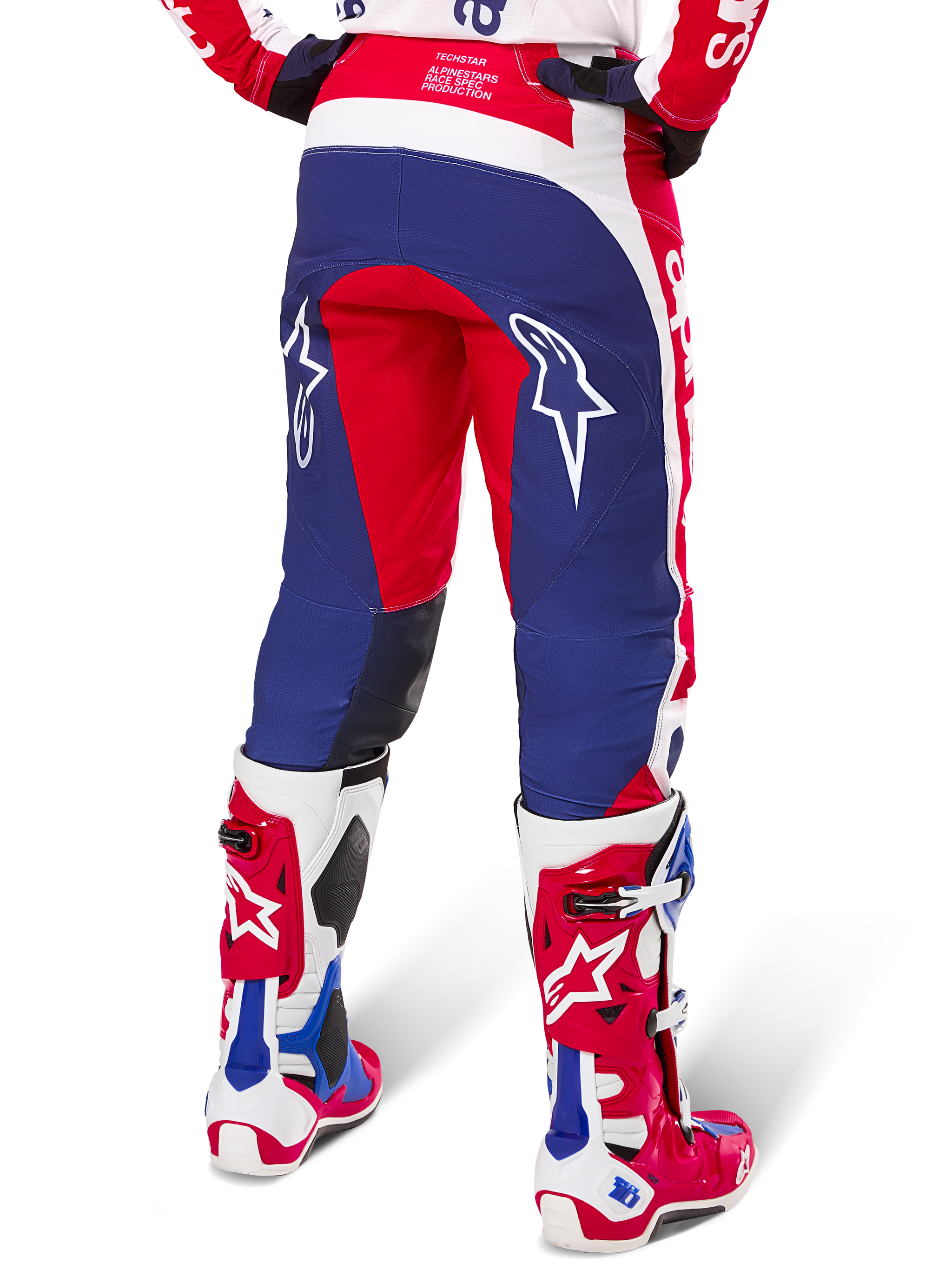 Alpinestars Limited Edition Techstar Fortitude bukser, motocross-bukser, rød, hvid og blå, set bagfra båret med matchende røde og hvide støvler, hvide stjernelogoer på lårene, holdbart multi-panel design til professionel off-road racing