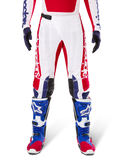 Alpinestars Limited Edition Techstar Fortitude bukser, motocrossbukser, klar rød, hvid og blå, vist med matchende udstyr inklusiv blå beskyttelsesstøvler og handsker, hvid konstruktion med rød grafik, sorte læderknæpaneler og laserskårne perforeringer, professionelt off-road racerudstyr