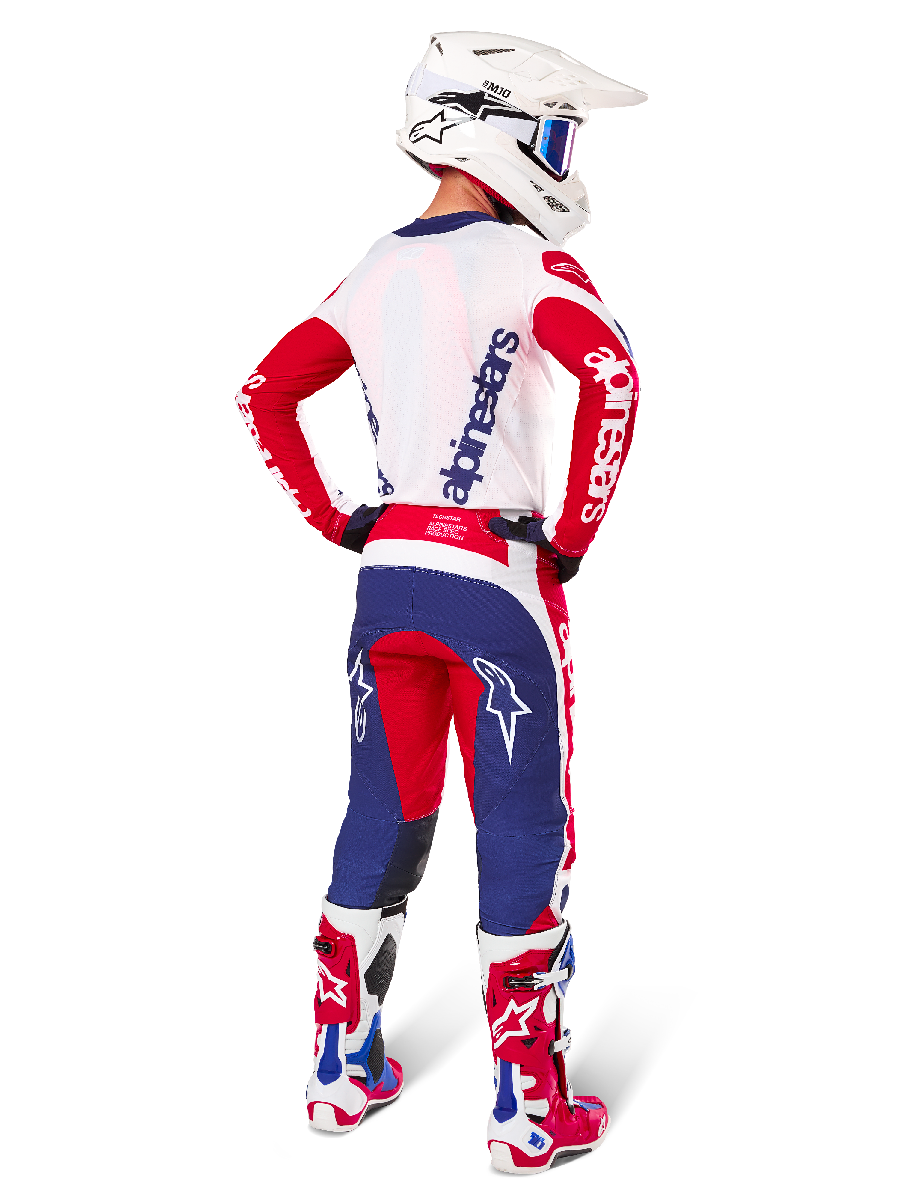 Alpinestars Limited Edition Techstar Fortitude bukser, motocrossbukser, rød, hvid og blå, vist på en kører bagfra med matchende trøje, støvler og hjelm, atletisk pasform og markant logoplacering