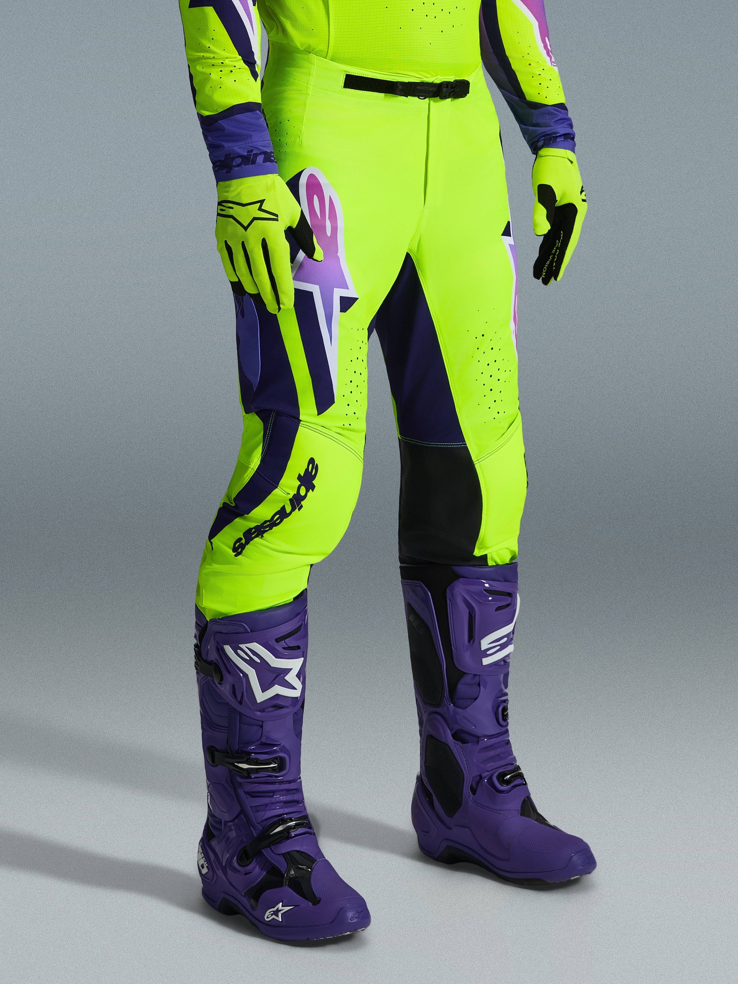 Alpinestars 2026 Supertech Vista bukser, motocrossbukser, neon gul, lilla og sort, båret med matchende lilla støvler og gule handsker, markant branding på låret og en atletisk performance-pasform