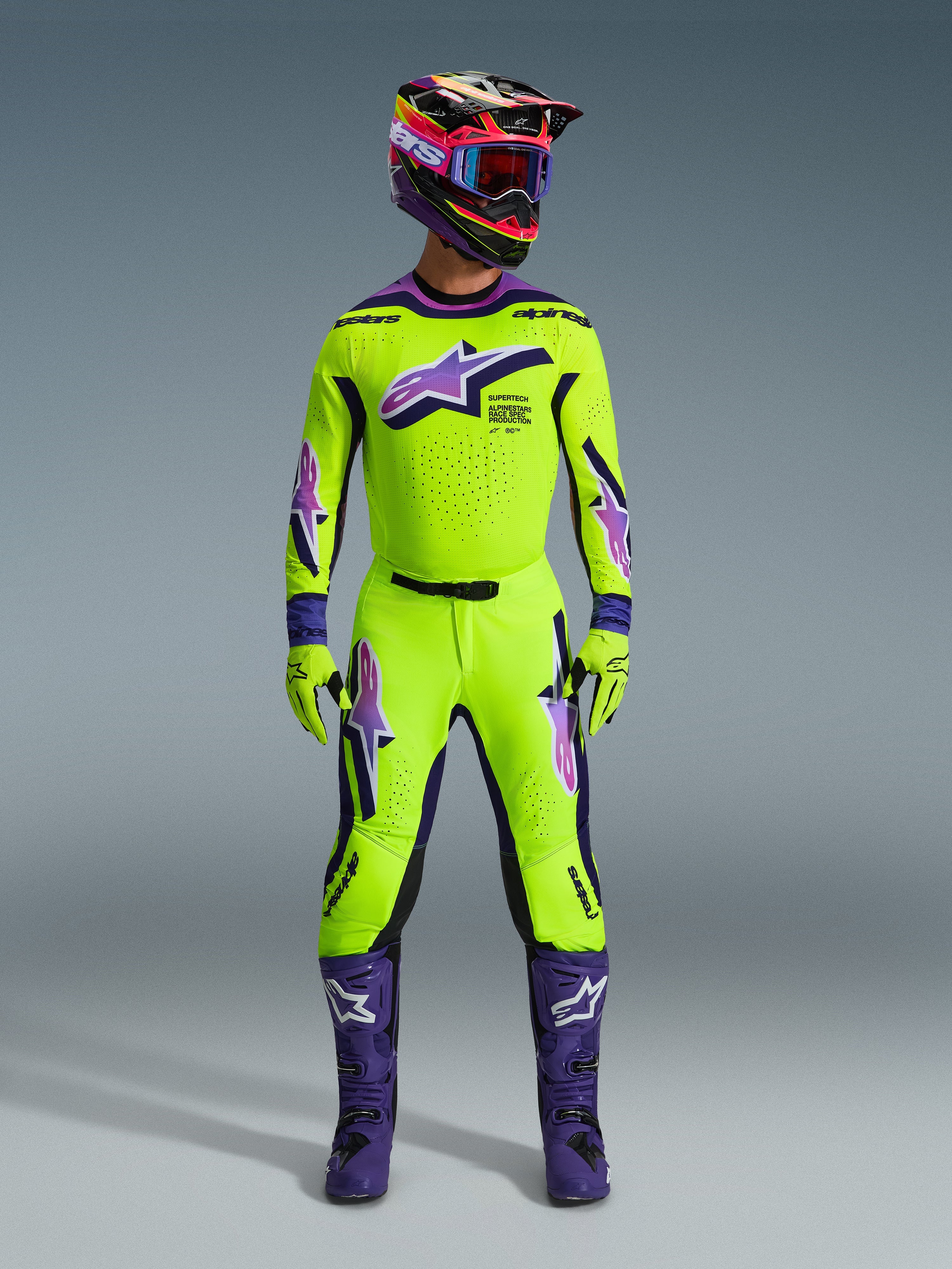 Alpinestars 2026 Supertech Vista Gear Set, motocross-raceroutfit i neongul og lilla, komplet med matchende flerfarvet hjelm, neongul trøje og bukser med lilla og hvide logoer, lilla støvler og koordinerende handsker til terrænkørsel