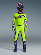 Alpinestars 2026 Supertech Vista bukser, motocrossbukser, neongul med lilla og sorte detaljer, båret som en del af et koordineret racersæt med matchende trøje, hjelm og lilla støvler, med en professionel atletisk pasform og markante logoer til off-road performance.