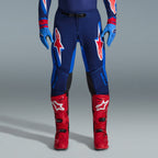 Alpinestars 2026 Supertech Vista udstyrssæt, motocrossbukser i navy og klar blå med røde og hvide logoer, kombineret med lyseblå handsker og klare røde motocrossstøvler, professionelt racerudstyr.