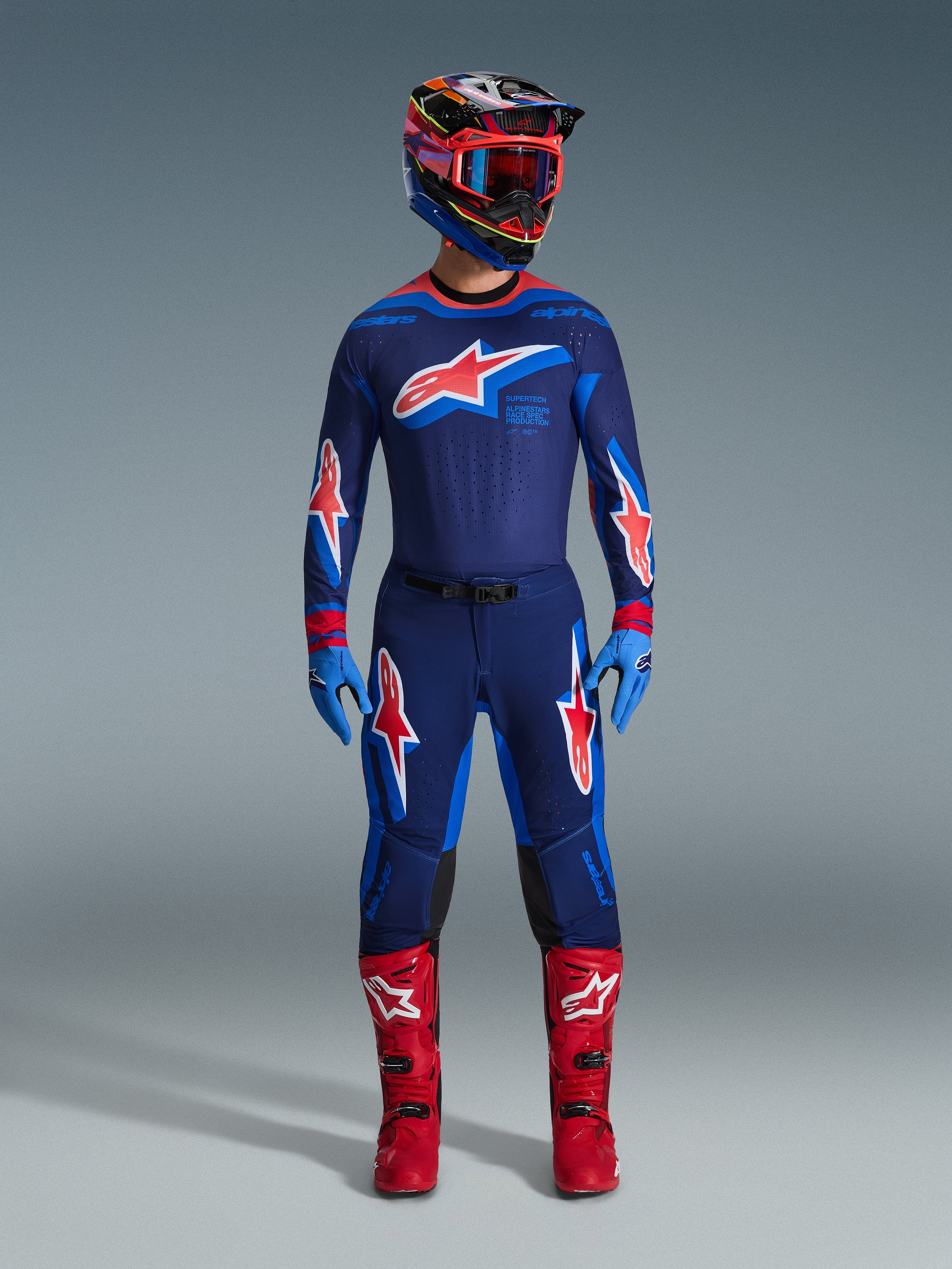 Alpinestars 2026 Supertech Vista Gear Set, komplet motocross-raceroutfit, mørkeblå jersey og bukser med røde og hvide stjernelogoer, multifarvet hjelm med røde goggles, lyseblå handsker og knaldrøde støvler, professionelt MX-udstyr
