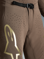 Alpinestars Begrænset Udgave Supertech Air Gold bukser, motocrossbukser i brun med guld Astars-logo, SX1 magnetisk spænde og perforeringer.