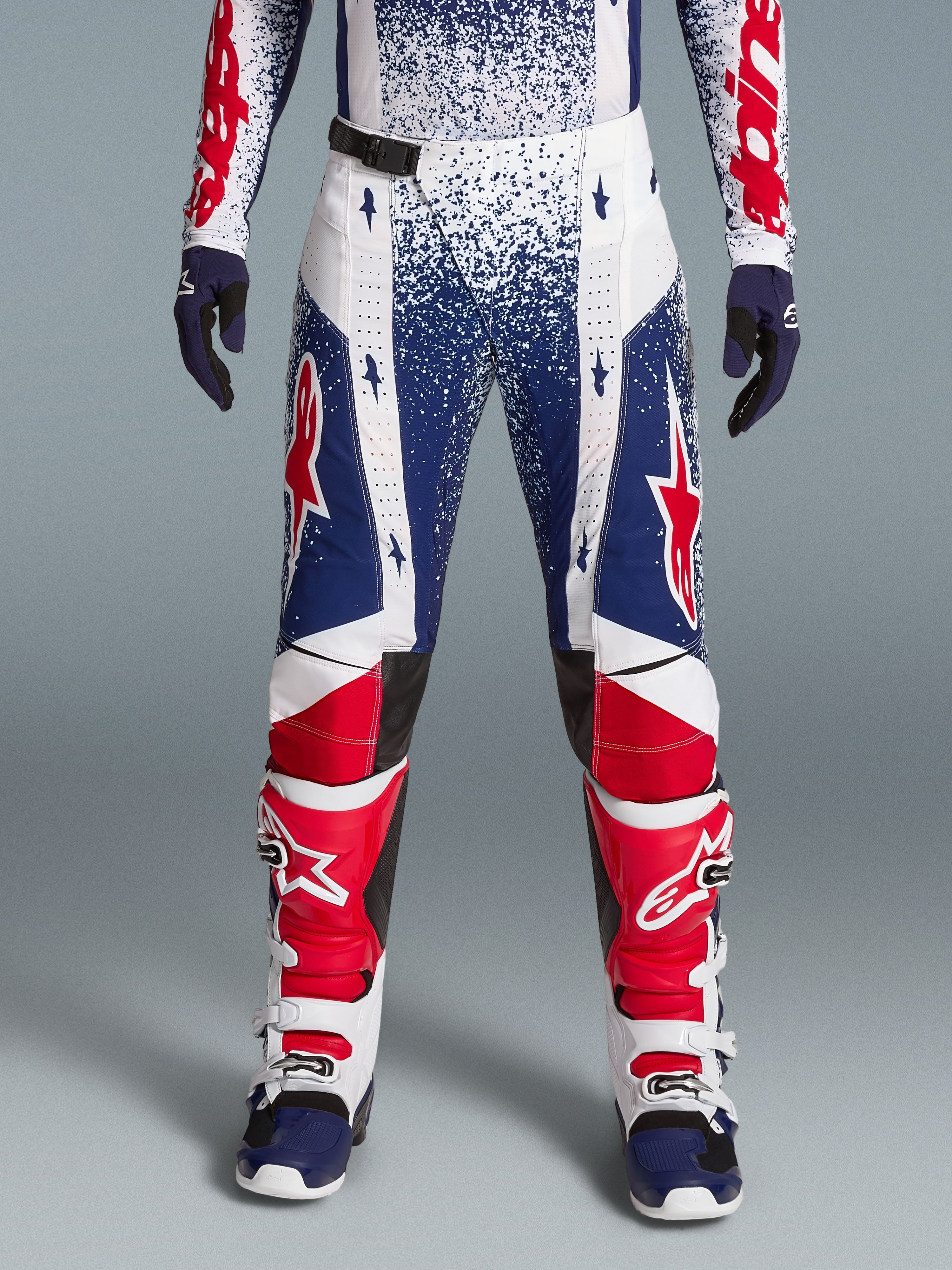 Alpinestars begrænset udgave Techstar Unity kompletsæt, rød, hvid og blå spættede motocrossbukser med racingstøvler.