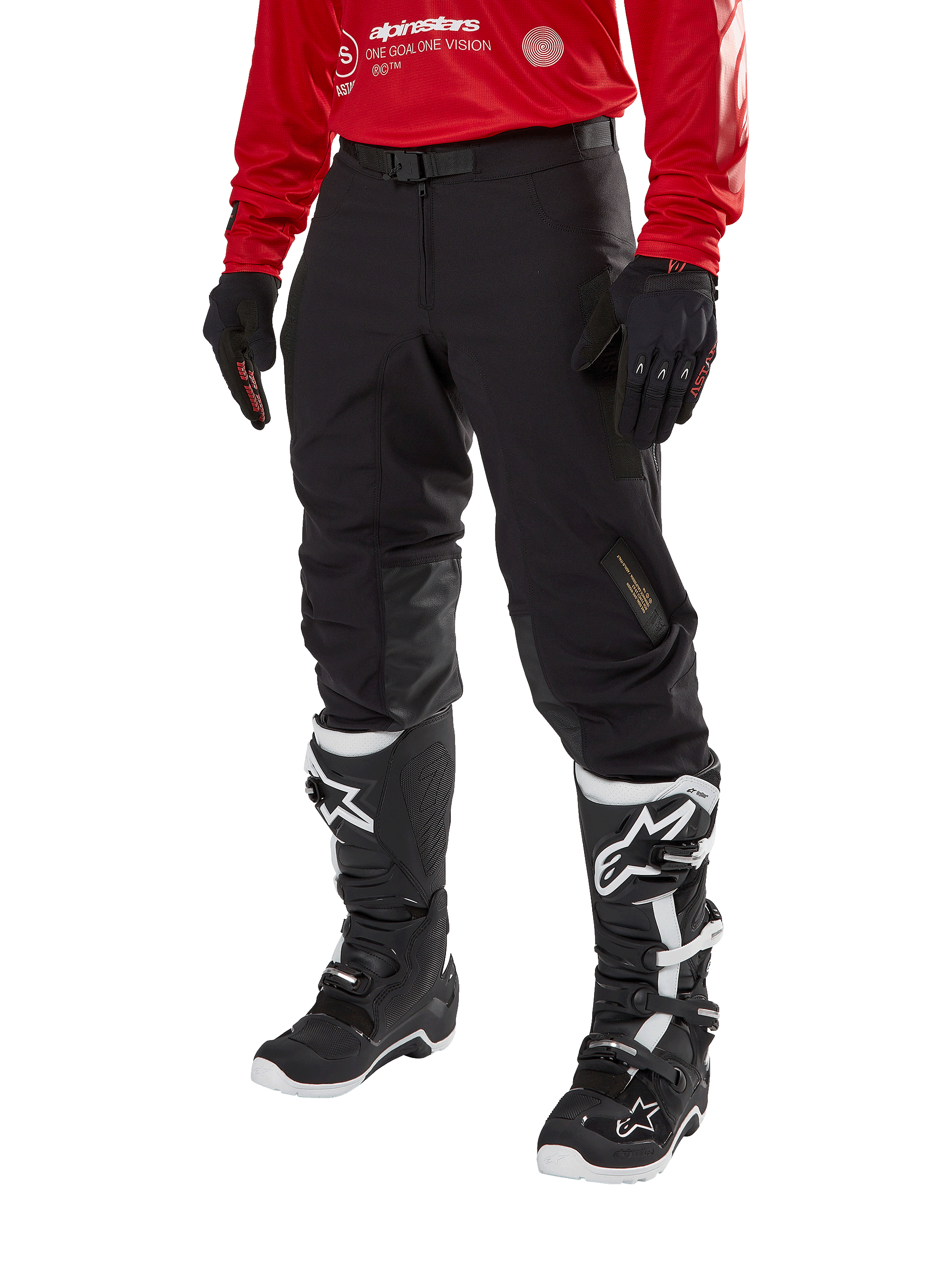 Alpinestars Techdura Pants, Black off-road motorcycle pants, worn with a red long-sleeve jersey and black and white motocross boots, featuring rugged stretch polyamide construction, leather inner knee reinforcements, and an adjustable buckled belt for enduro riding.