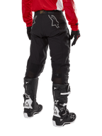 Alpinestars Techdura Pants, Off-Road Enduro Pants, Black, rear view showing gray star logos on the seat, worn with a red long-sleeve jersey and black and white Tech 7 boots, rugged textile construction for adventure riding