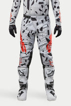 Alpinestars 2024 Techstar Rantera bukser, motocrossbukser, Haze Gray Camo, båret med matchende trøje, sorte handsker og hvide støvler, med sort pletmønster og rød Alpinestars-branding, holdbart design til off-road racing