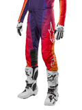 Alpinestars 2024 Techstar Pneuma bukser, motocross off-road bukser, mørkelilla, orange og mørkeblå, hvidt logo på låret, herunder hvide handsker og hvide støvler, højtydende udstyr til terrænkørsel