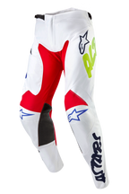 Alpinestars 2024 Racer Hana bukser, motocross-bukser, hvid multifarvet, med røde og sorte indvendige knæpaneler, blå Astars-logoer og neongul branding, forbuede ben med skraldelukning i taljen, holdbart tekstiludstyr til terrænkørsel
