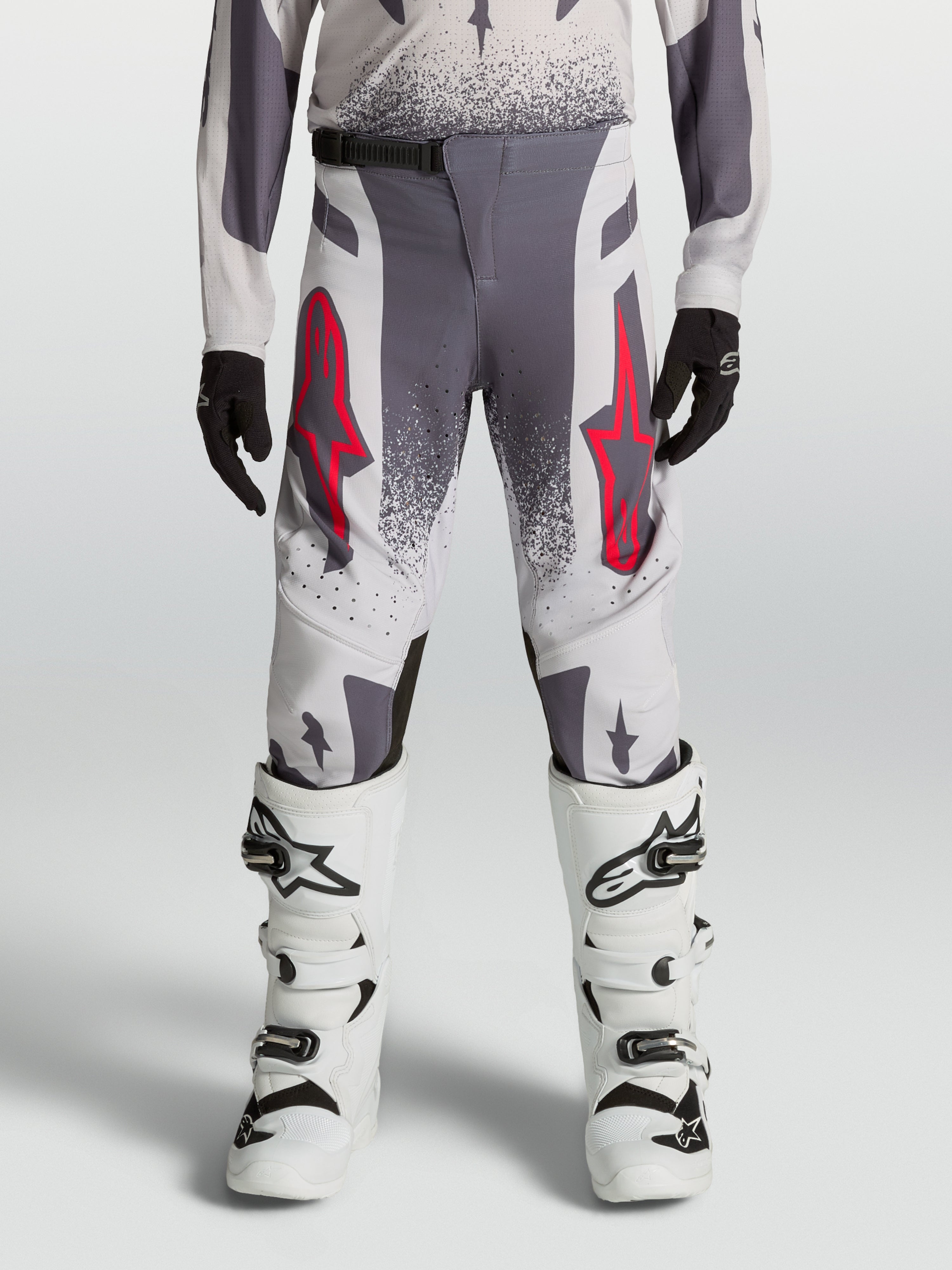 Alpinestars Supertech Swan bukser til ungdom, højtydende motocrossbukser i gråt og lilla tekstil med røde detaljer.