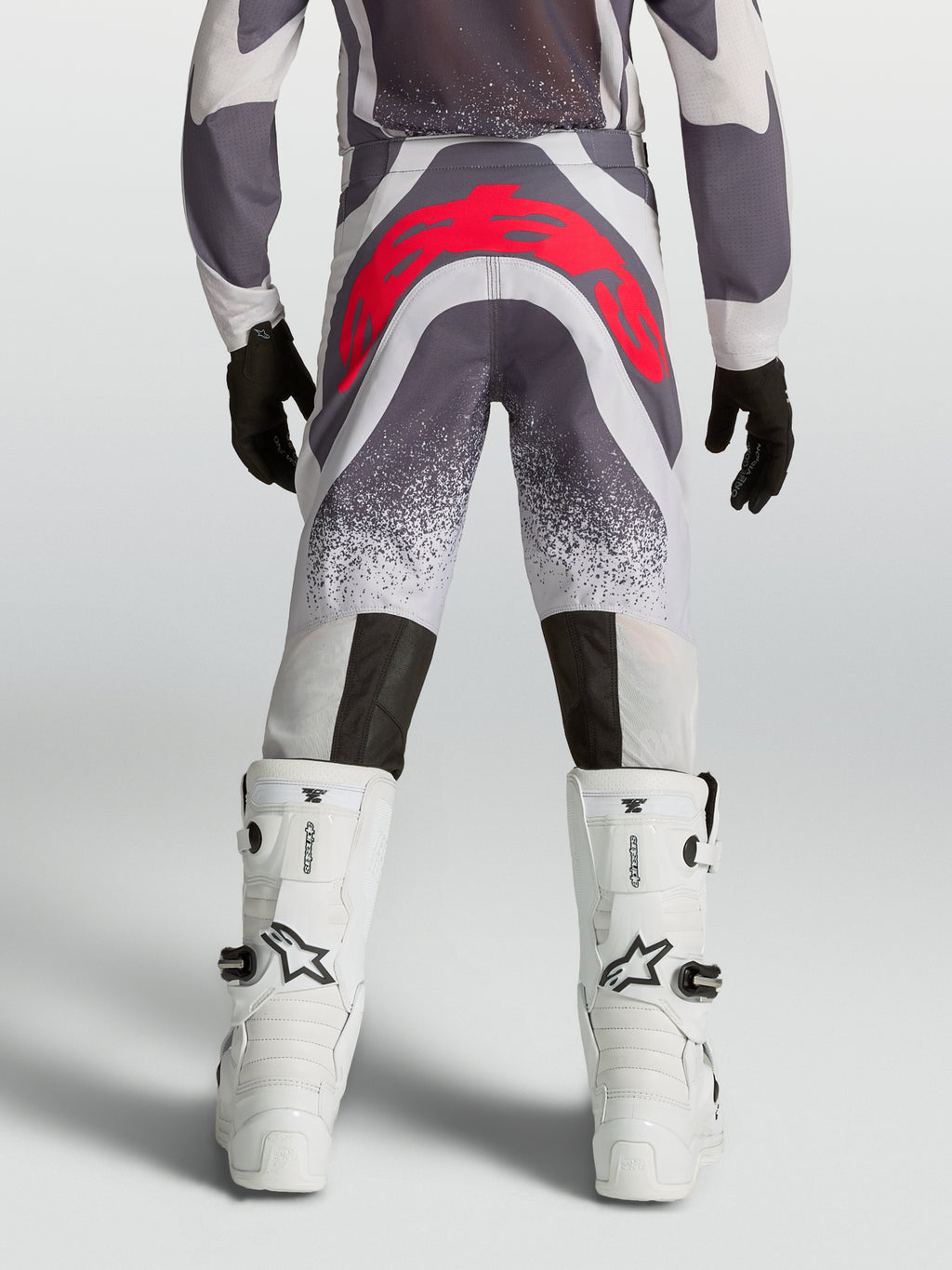 Alpinestars Supertech Swan motocrossbukser til unge, grå og rød, set bagfra med atletisk pasform og forstærket sæde.