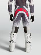 Alpinestars Supertech Swan motocrossbukser til unge, grå og rød, set bagfra med atletisk pasform og forstærket sæde.